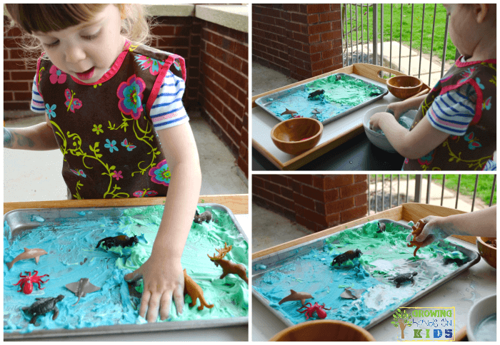 Earth day sensory play activity with shaving cream and miniature animals.