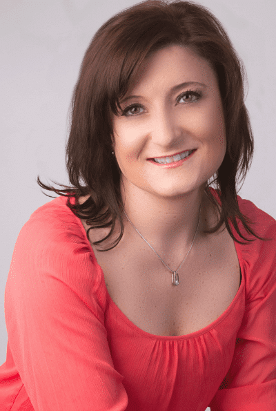 Photo of a women with brown hair and a salmon colored shirt.