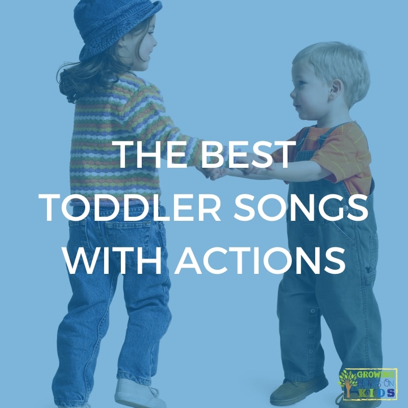Two children holding hands and dancing. Blue overlay with white text that says "The Best Toddler Songs with Actions".