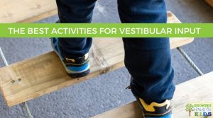 Child in blue pants and sneakers walking on a wood bridge. The words The Best Activities for Vestibular Input are written on the top of the graphic with a green background.