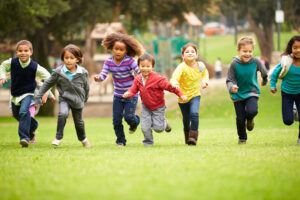 Group Of Young Children Running Towards Camera In Park