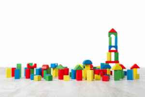 Colored building blocks laying on the floor with a block tower on the right side.