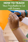 Background is a picture of a child holding a pair of blue safety scissor, cutting across an orange piece of paper. Adult hands on holding the paper on either side of the child's hands. Green text overlay across the top with white text says "How to teach your preschooler to cut with scissors".