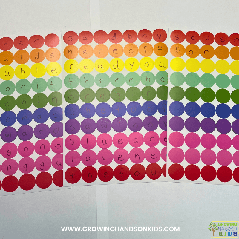Three sheets of colored dot stickers laying on a piece of white paper.