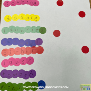 Picture of dot stickers with letters lined up on a paper to spell out spelling words.